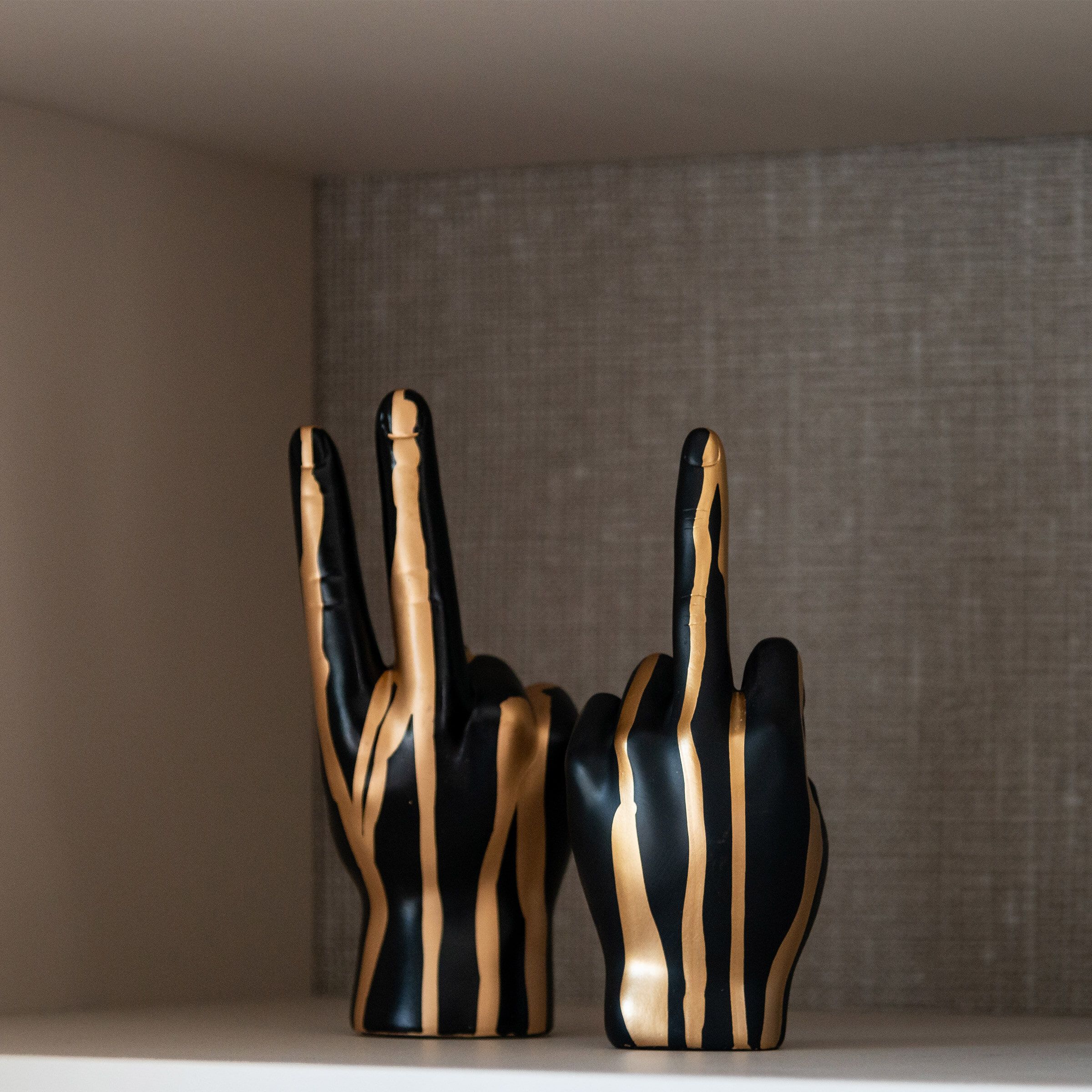 Elegant zwarte en gouden handfiguur – Richmond Decoratie Middelvinger